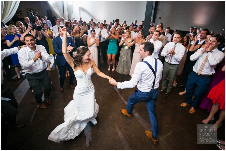 The guests make a dance circle around the bride and groom at Foundry at puritan mill wedding reception.