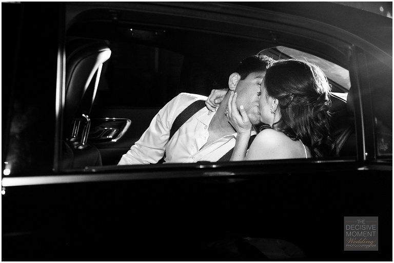 Bride and groom share a kiss in the getaway car at end of the night at Foundry at Puritan Mill Wedding